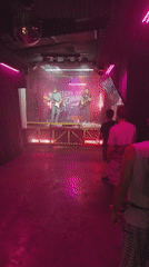 Live band performs under pink lights at a Tbilisi venue