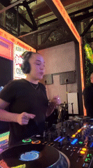 Behind the decks in a dark room, deep in the mix