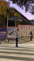 Street performer juggles basketball on umbrella in Buenos Aires