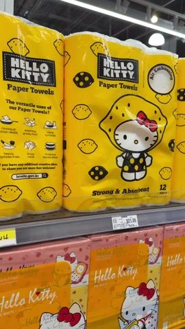 The video shows two packages of Hello Kitty Paper Towels on a store shelf. The packages are bright yellow, and feature images of Hello Kitty and lemons. Each package contains 12 rolls and costs $21.99. Below the paper towels are several packages of Hello Kitty tissue.