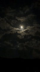 Full moon observed through clouds over Sofia evening sky