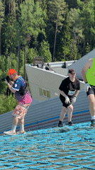 Three Athletes Run Up Netted Ski Jump During Timed Event