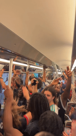 Young adults celebrate on crowded Paris subway car