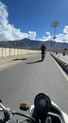 Standing on a motorcycle in the Ladakh mountains