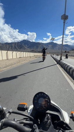Standing on a motorcycle in the Ladakh mountains