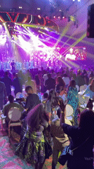 Live band performs to dancing crowd at indoor venue