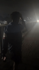 Rainy night moving through Uyo streets, bottle in hand