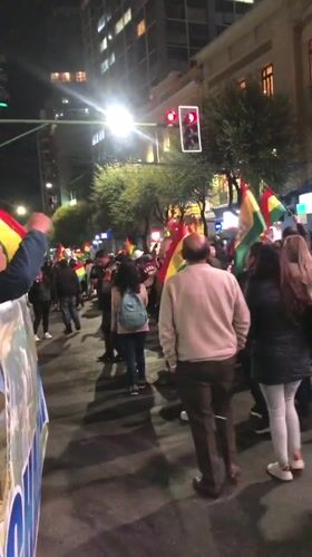 Nighttime flag-waving procession moves through La Paz streets