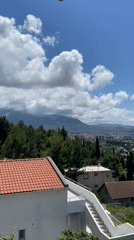 Man poses for photos on balcony in Montenegro coastal town