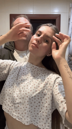 Woman styles hair in bathroom mirror in Klin, Russia