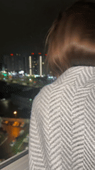 Family evening captured in Izhevsk apartment overlooking city lights