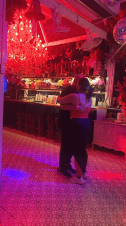 Couple dances in decorated Pattaya bar with colorful lighting