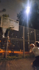 Woman plays nighttime basketball on Moscow court