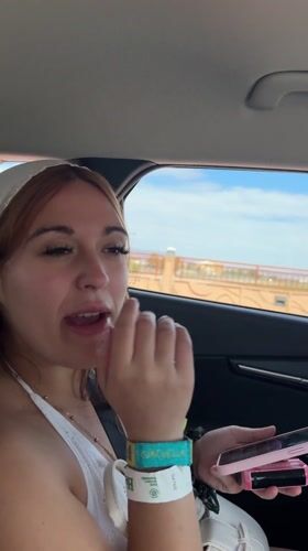 Woman laughing with phone in car passenger seat, La Quinta
