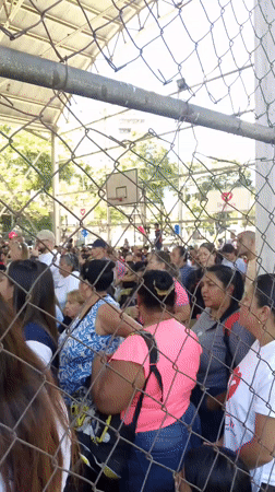 Large crowd gathers under covered structure in Caracas
