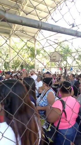 Large crowd gathers under covered structure in Caracas