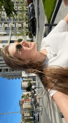 Woman films selfie video while walking sunny Belgrade street