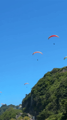 Colorful paragliders spotted over Kuta Selatan cliffs