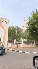 Car drives past ornate mosque gate in Abuja