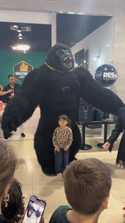 Group poses with costumed gorilla performer in Russian mall