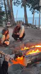 Campfire gathering with drums, carved stone, and bamboo nearby