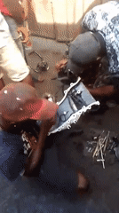 Mechanics repair car engine at outdoor shop in Onitsha