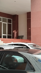 Girl gestures on platform near building in Ho Chi Minh City