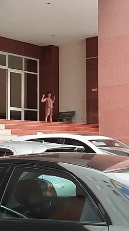 Girl gestures on platform near building in Ho Chi Minh City