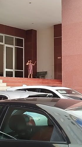 Girl gestures on platform near building in Ho Chi Minh City