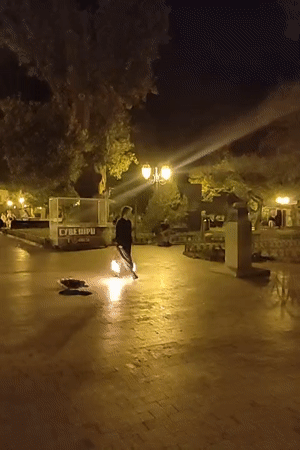 Fire performance lights up a wet Odesa plaza at night