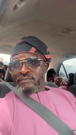 Man in pink shirt and aviator sunglasses recorded in Ado