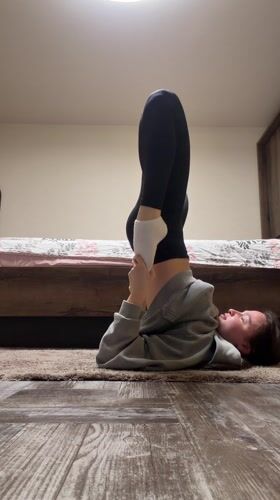Woman exercises, stretches in bedroom in Pernik, Bulgaria