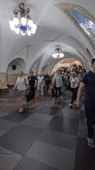 Moving through a grand underground metro station at rush hour
