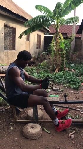 Man exercises on homemade equipment in Akwanga courtyard