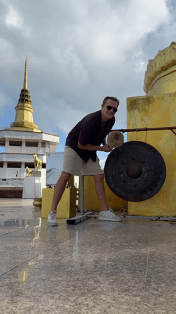 Man strikes gong at Buddhist temple in Thailand