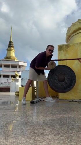 Man strikes gong at Buddhist temple in Thailand