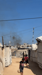 Morning scenes captured across Gaza settlement amid distant smoke