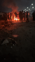 Group gathers around nighttime bonfire in Alaguntan, Nigeria