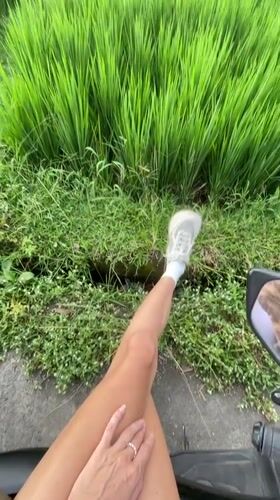 Scooter rider passes vibrant rice fields in Ubud