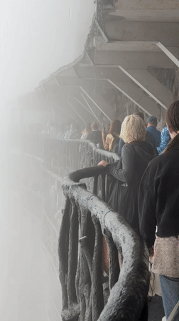 Tourists navigate misty Tianmen Mountain walkways during morning hours
