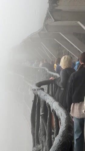 Tourists navigate misty Tianmen Mountain walkways during morning hours