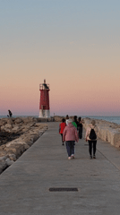 Evening visitors gather at Dénia lighthouse during sunset