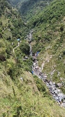 Woman plays with puppy in scenic Bhagsu valley