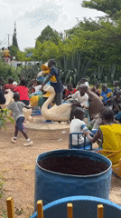 Children play while couple examines car engine in Nigeria