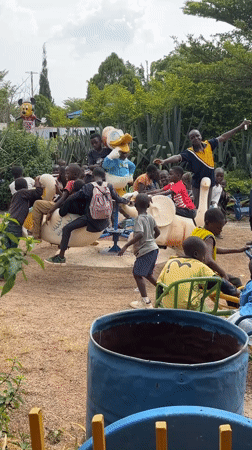 Children play while couple examines car engine in Nigeria