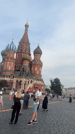 Tourists photograph Red Square landmarks under cloudy Moscow afternoon