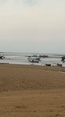 Calm Bali beach at dusk with moored boats and pastel skies