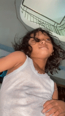 Child plays and smiles for camera in Gelam home
