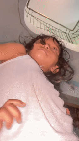 Child plays and smiles for camera in Gelam home