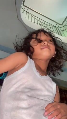 Child plays and smiles for camera in Gelam home